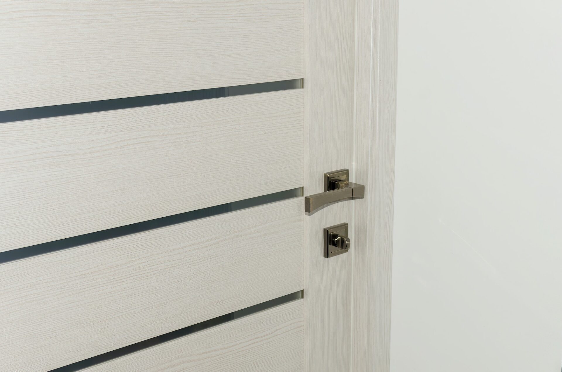 Close up of stylish new metal door knob on modern interior door.