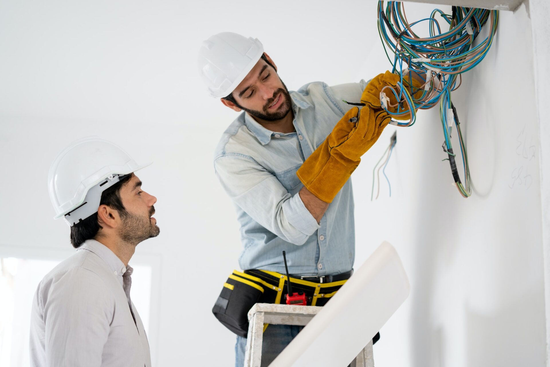 Electrician mounting wiring for electric sockets on the construction site of a new house.